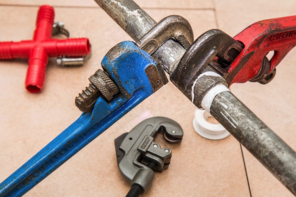 Pipe wrenches attached to a water line.