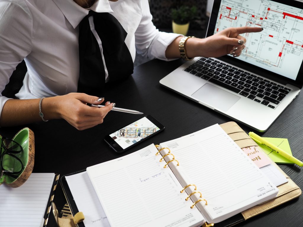 A property manager sitting at a desk pointing to a blueprint of an apartment.